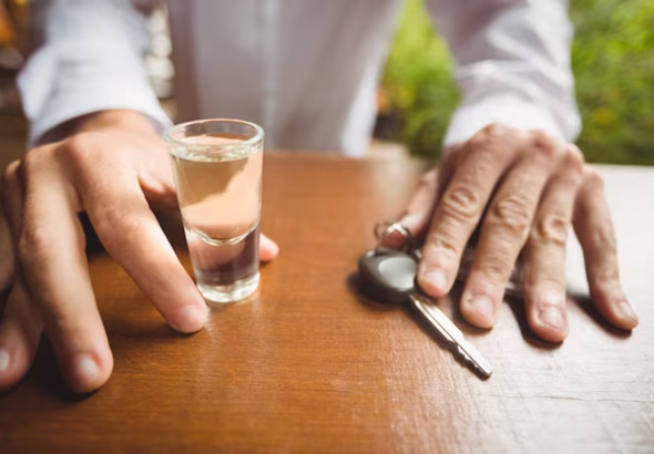 man-holding-glass-tequila-shot-car-key-bar-counter_107420-65518