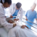 Team of doctors putting oxygen mask on a male senior patient face in the hospital